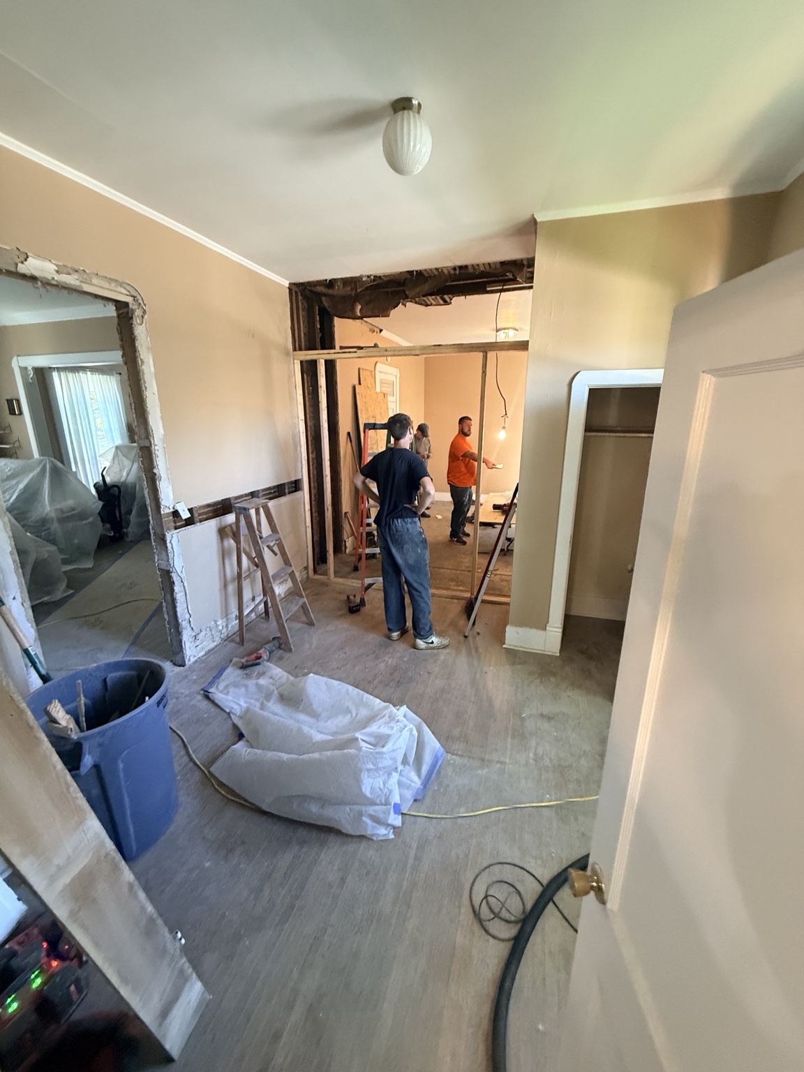 Crew at work inside a room with exposed wall framing