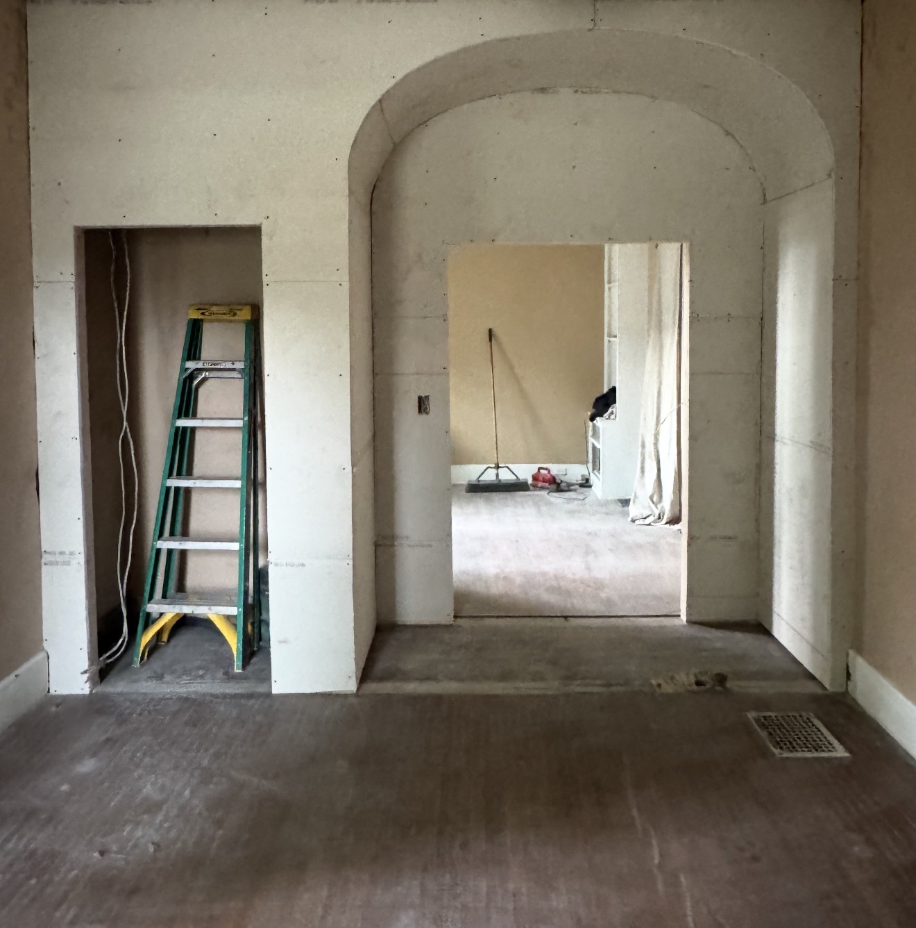 New drywall around an arched opening and adjacent recessed area