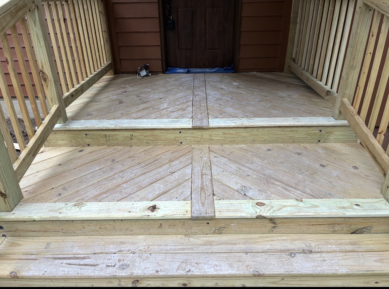 Wood porch stairs with diagonal landing boards and railings