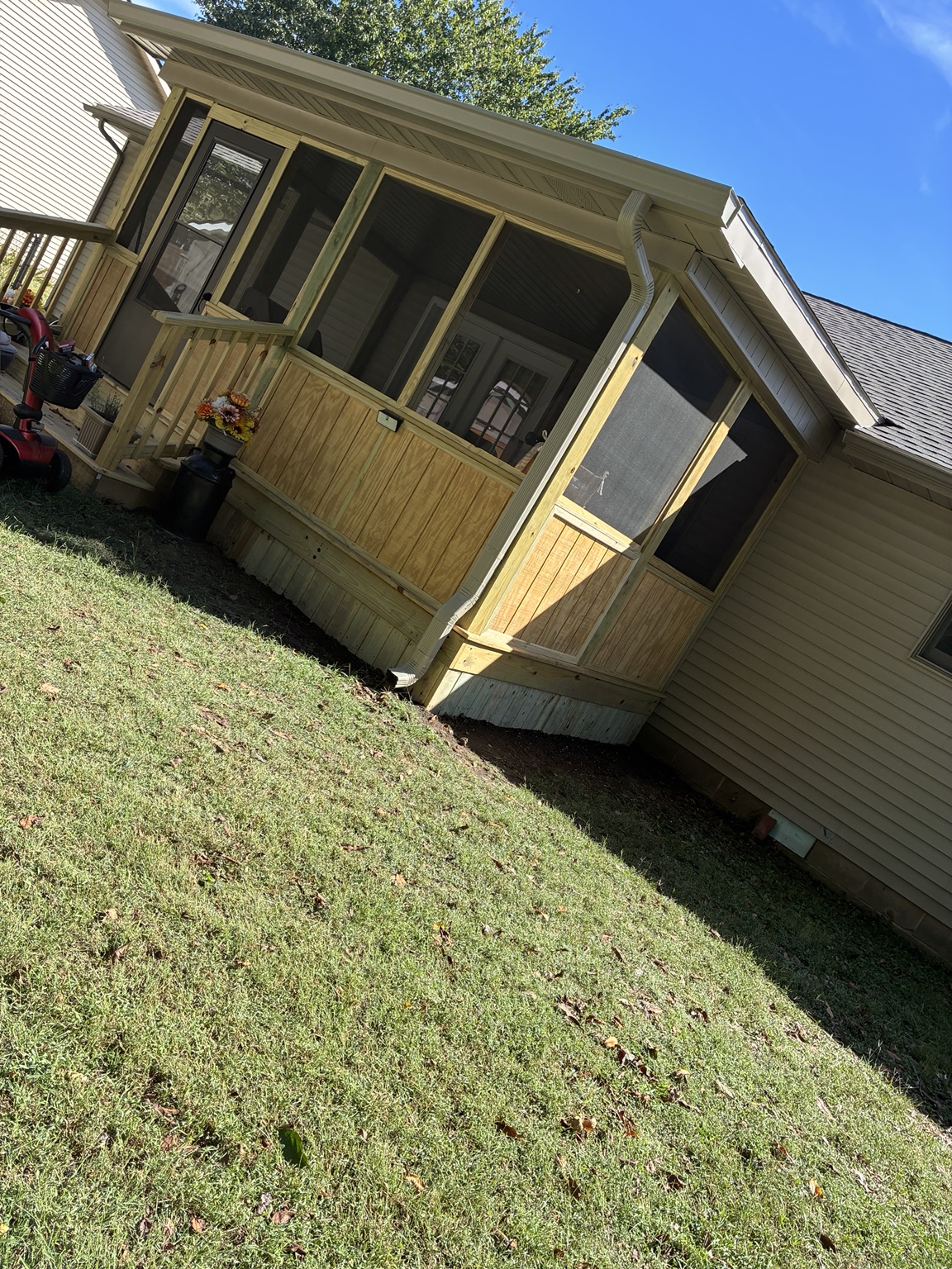 Screened porch with dark screen panels, wood lower panels and skirting