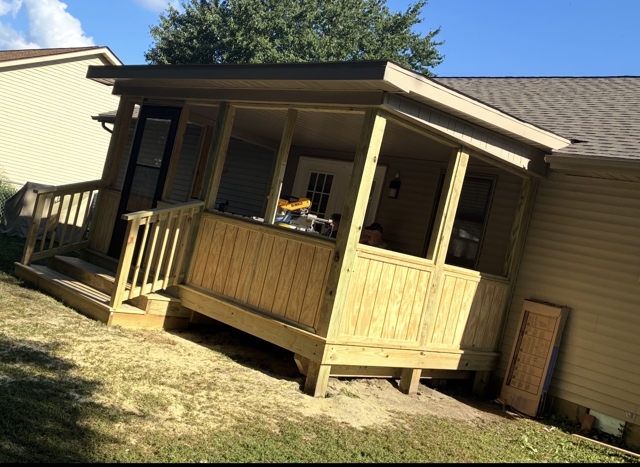 Open timber porch framing with wood lower panels during construction